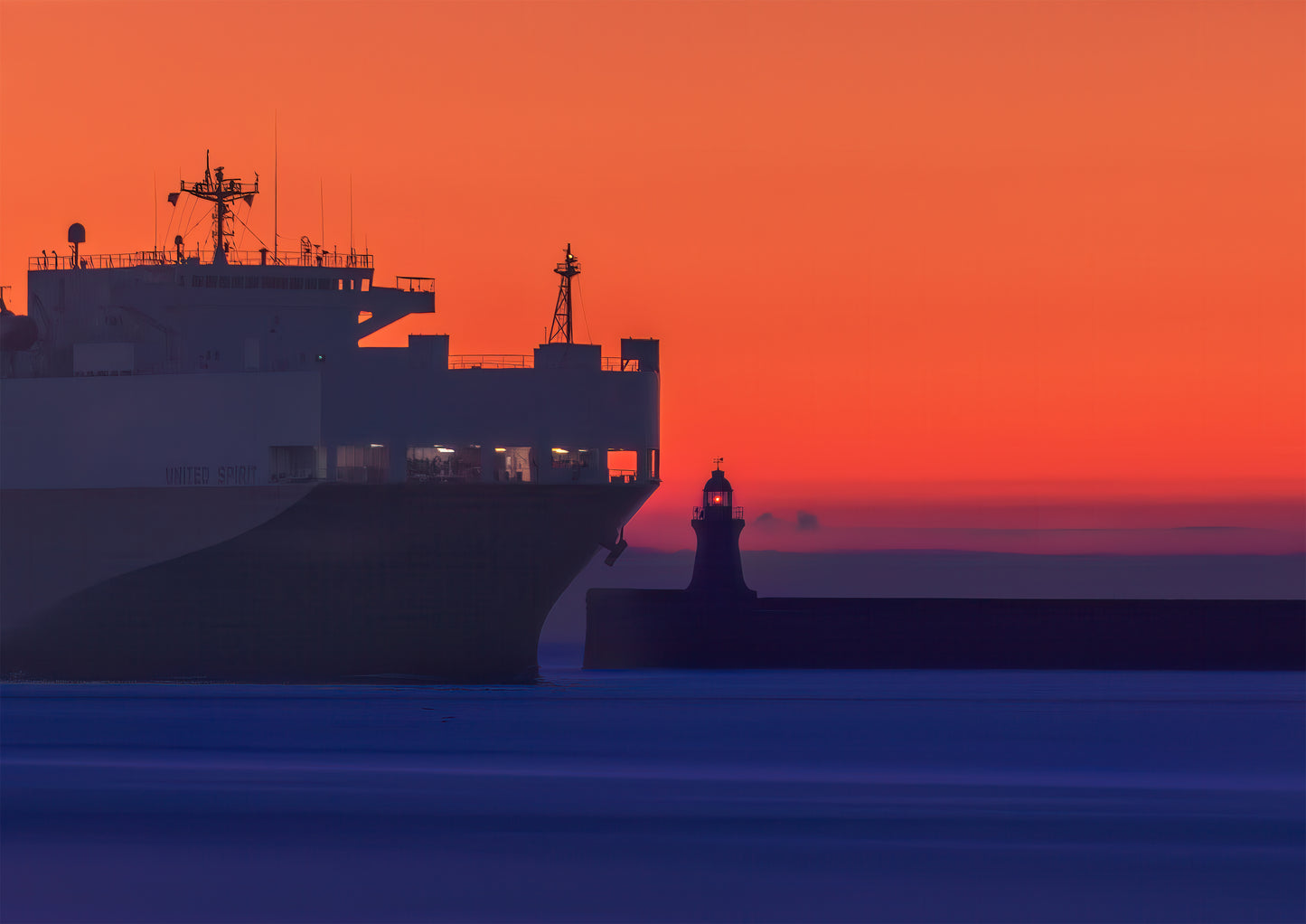 The United Spirit towering over South Shields Lighthouse as it comes in to port.