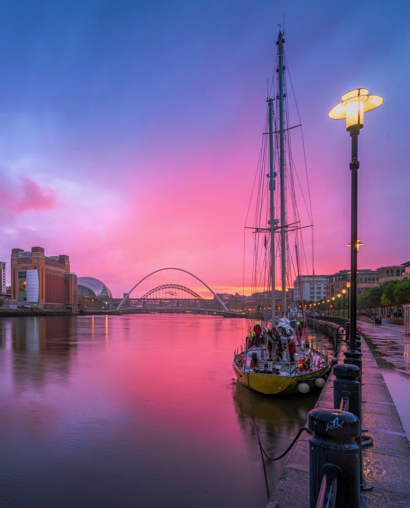Pink skies on Newcastle quayside during a rain shower.