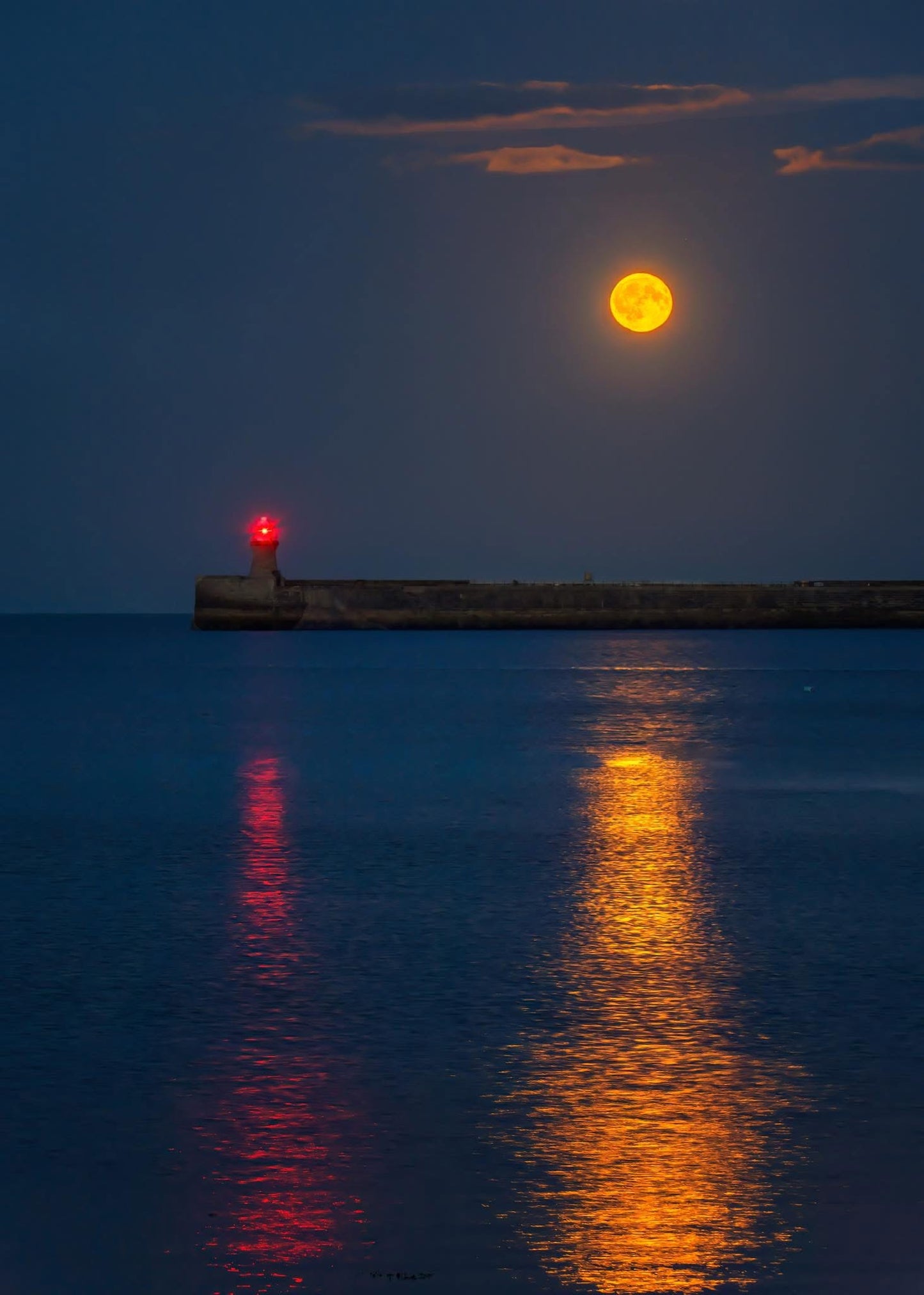The reflections of the full moon and South Shields lighthouse.
