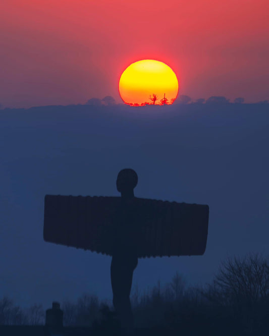 Beautiful red sun above the Angel of the North.