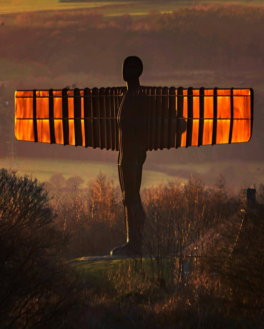 The Angel of the North with a golden glow at sunset.