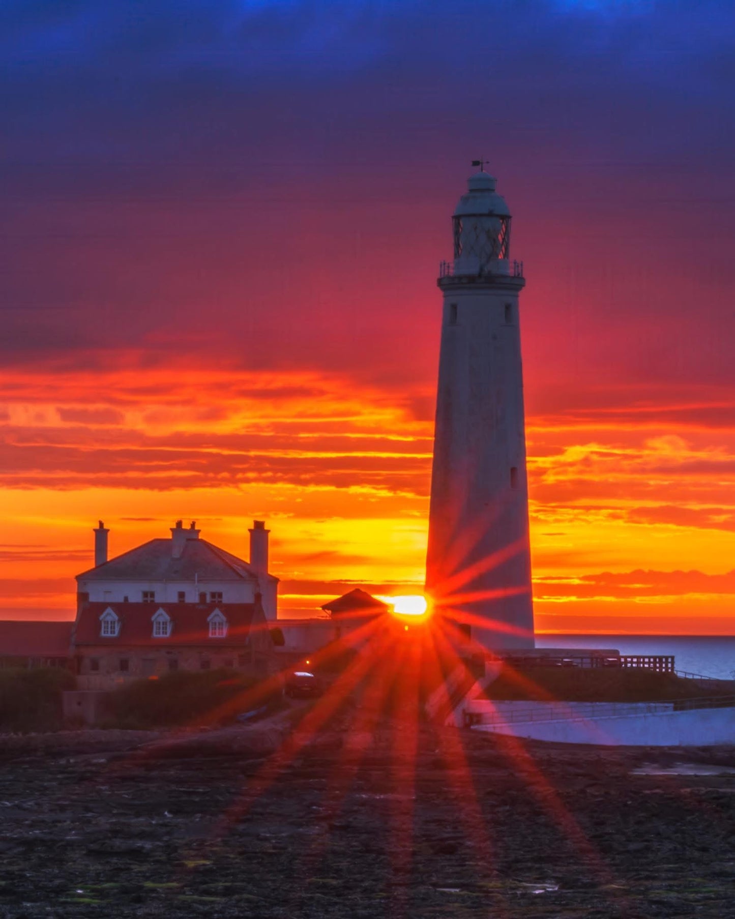 A close up of St. Mary’s Lighthouse during a vibrant sunrise.