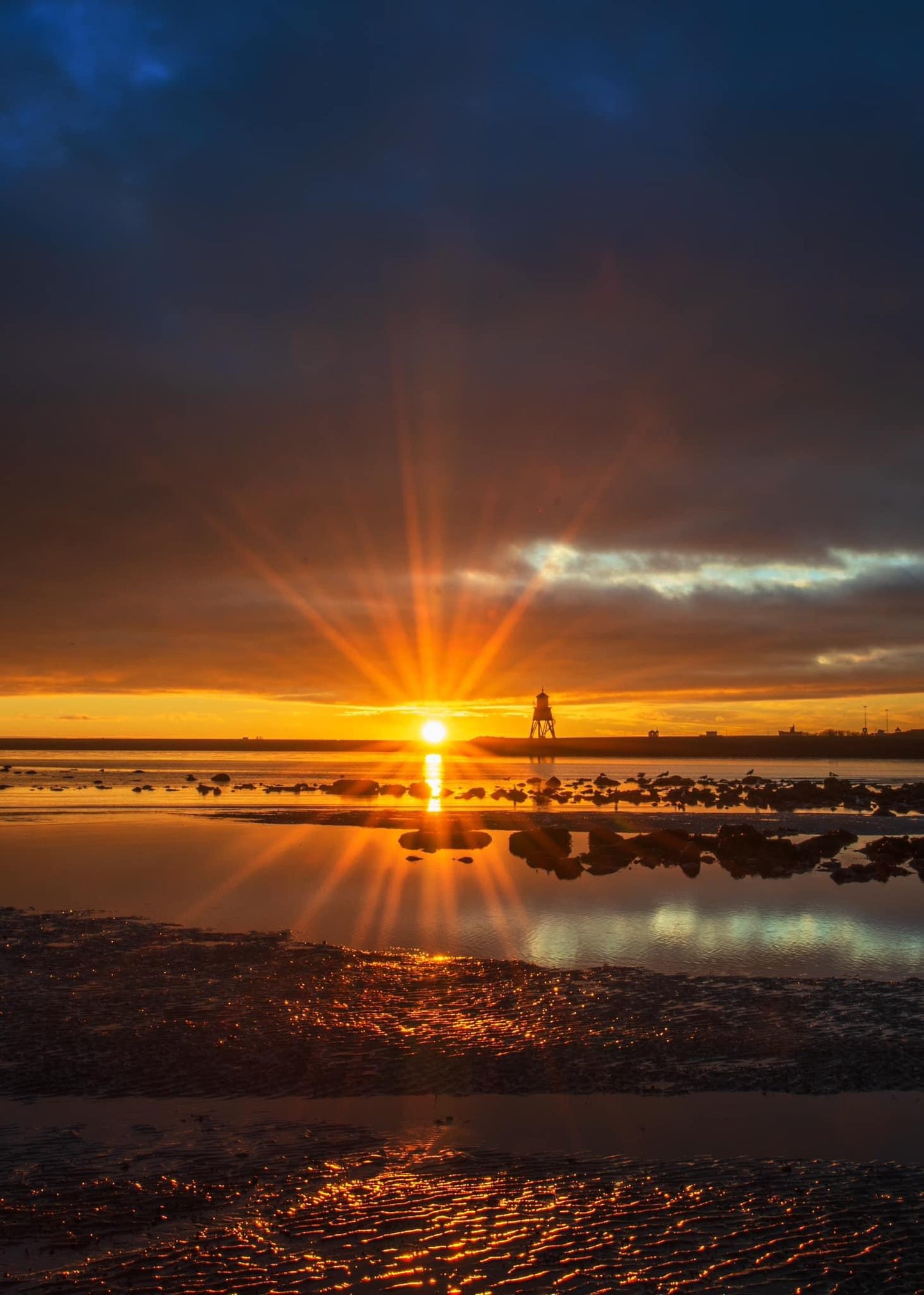 Sunburst over Herd Groyne Lighthouse.