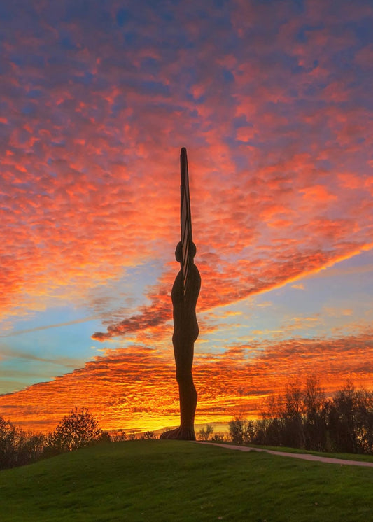 The Angel surrounded by golden lit clouds.