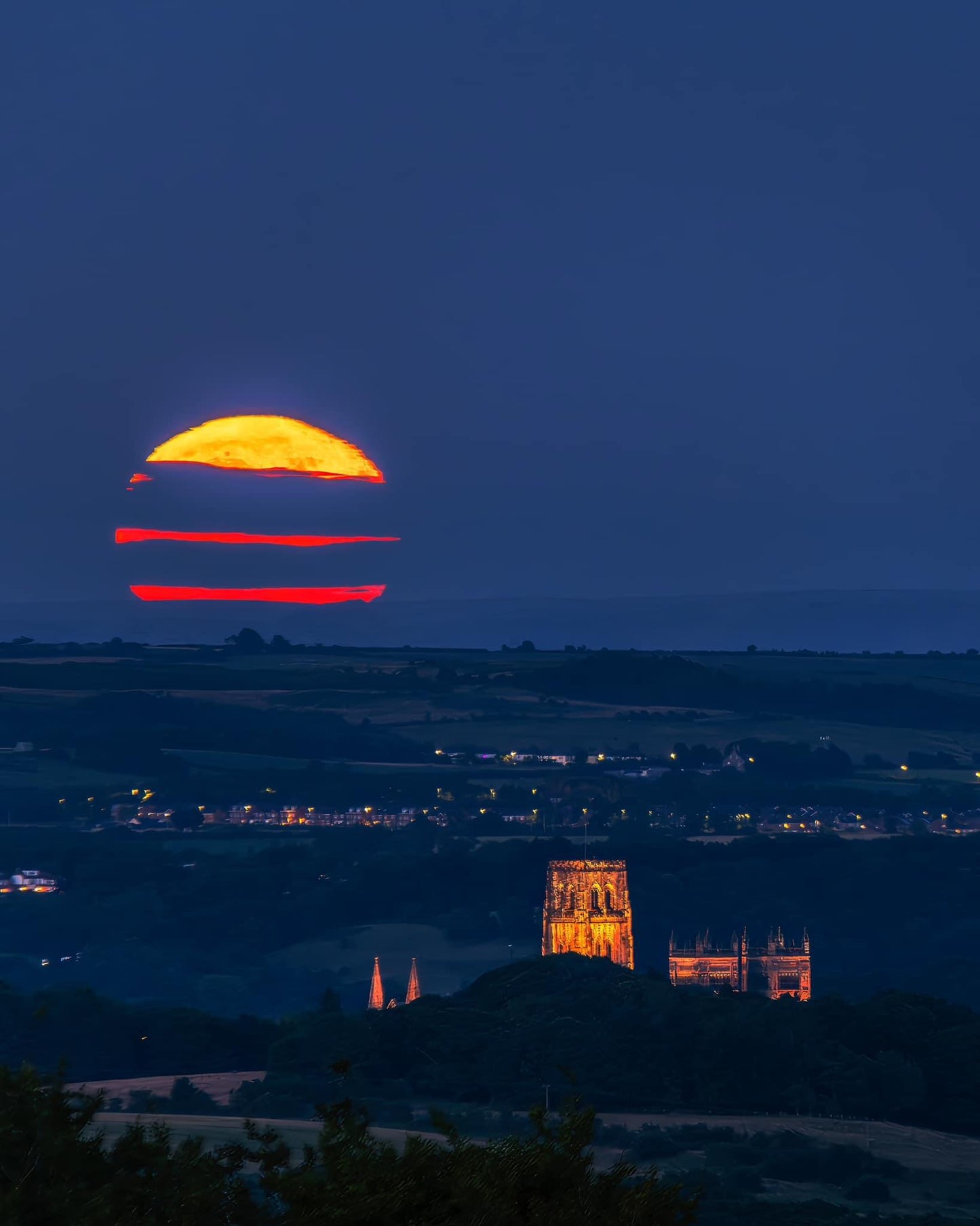 Durham Cathedral with stripy clouds across the full Buck Moon.