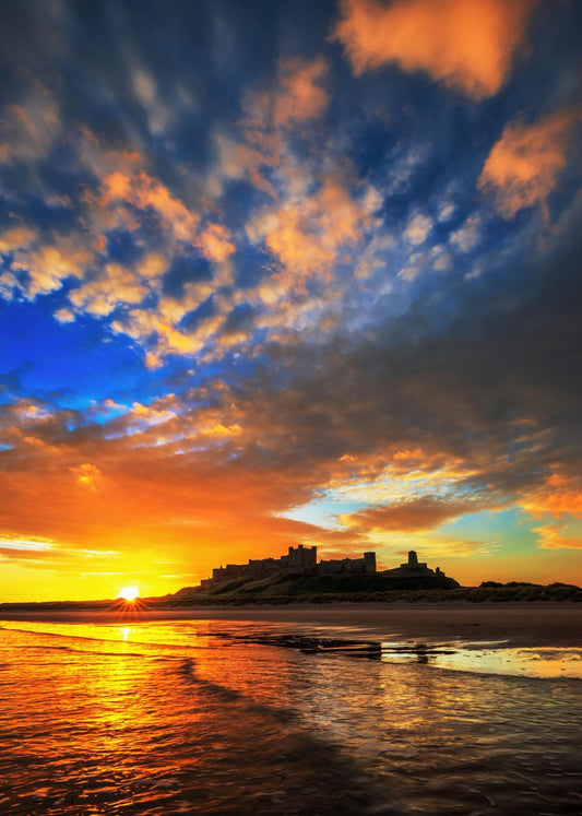 Vibrant sunrise sky at Bamburgh beach.