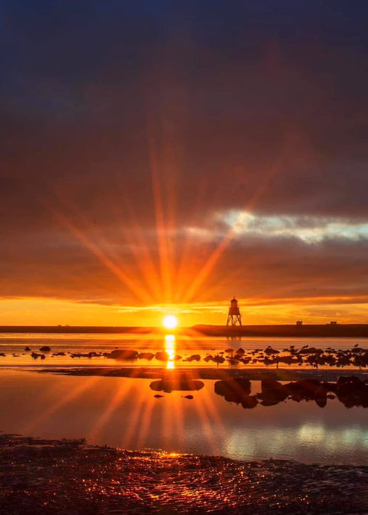Sunburst over Herd Groyne Lighthouse.