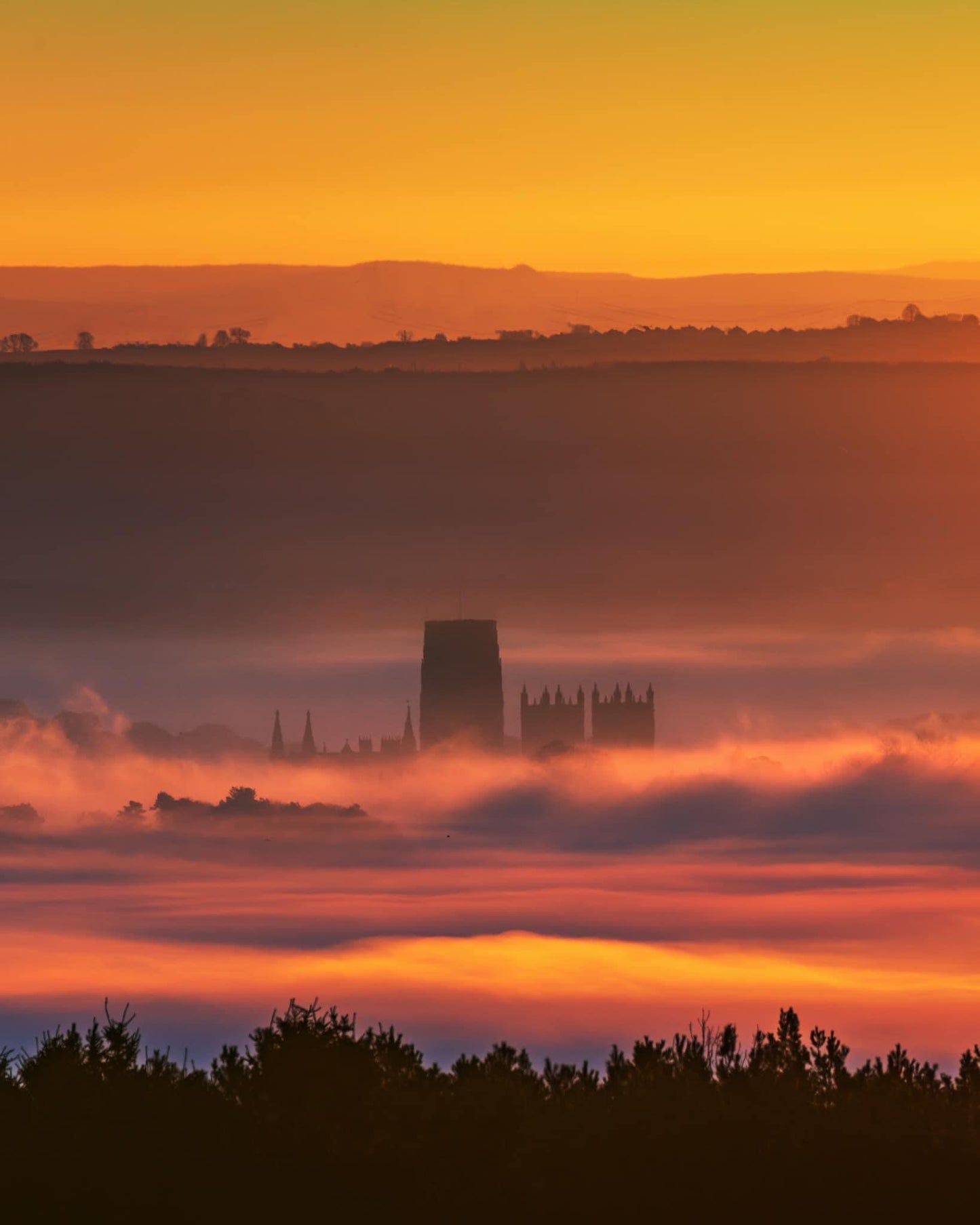 Durham Cathedral buried in the mist lit up by the riding sun.