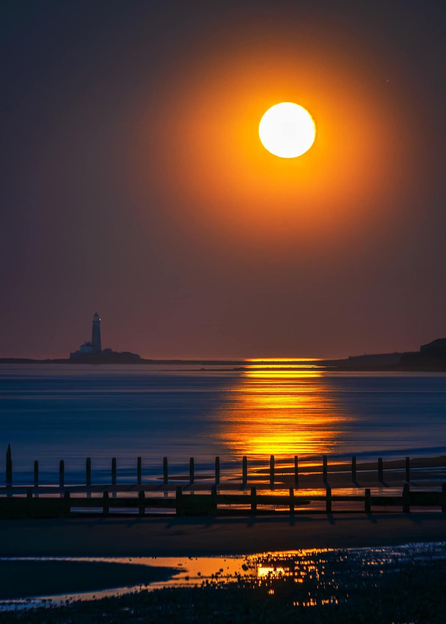 Glowing full moon looking towards St.Mary’s Lighthouse.