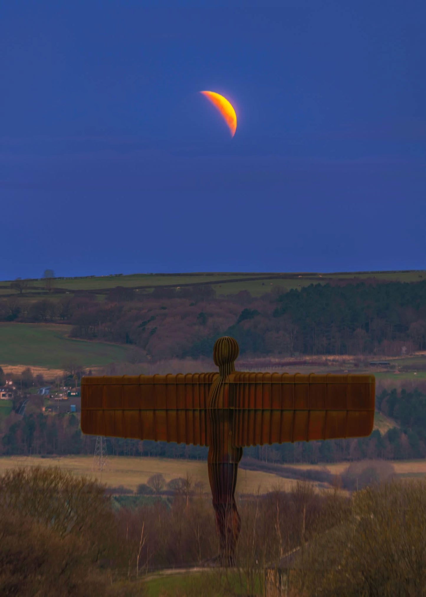 A partial lunar eclipse over the Angel of the North.