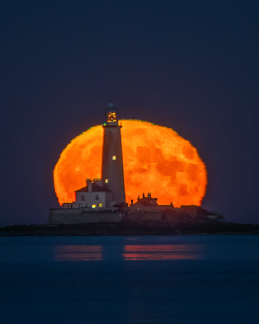 St. Mary’s Lighthouse in front of a   Huge moon.