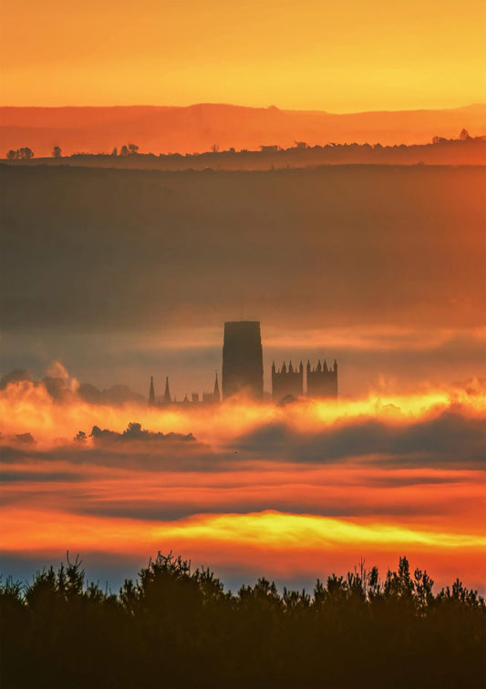 Durham Cathedral buried in the mist lit up by the rising sun.
