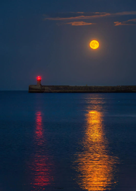 The reflections of the full moon and South Shields lighthouse.