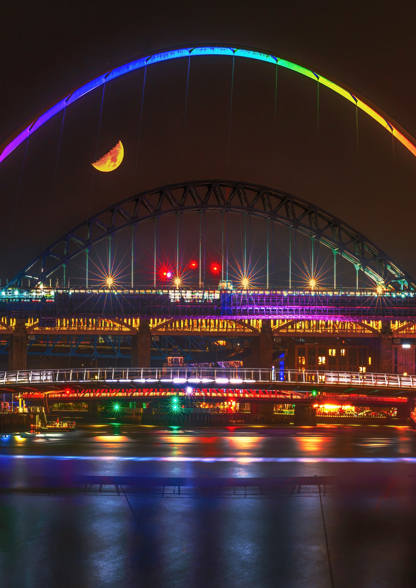 A half moon over a very colourful Newcastle Quayside.