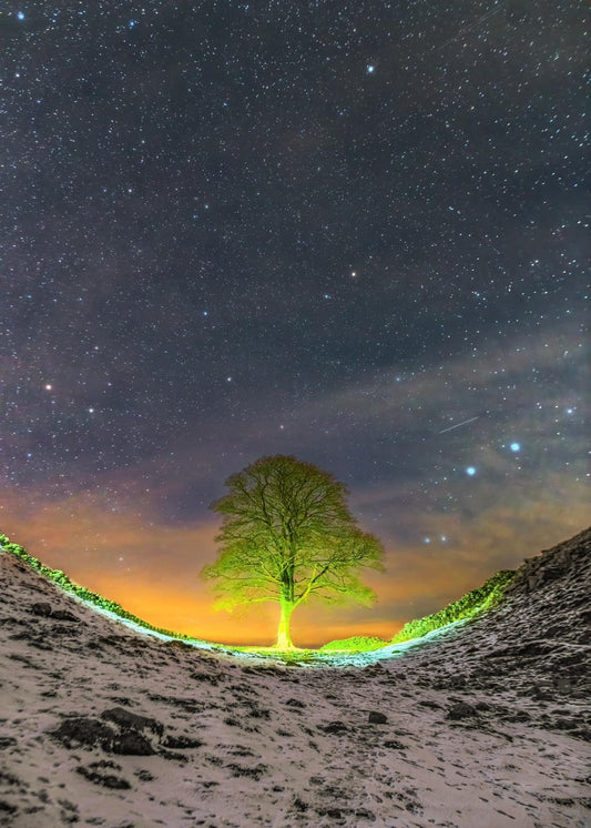 Walker's head lamp lights up  Sycamore Gap.