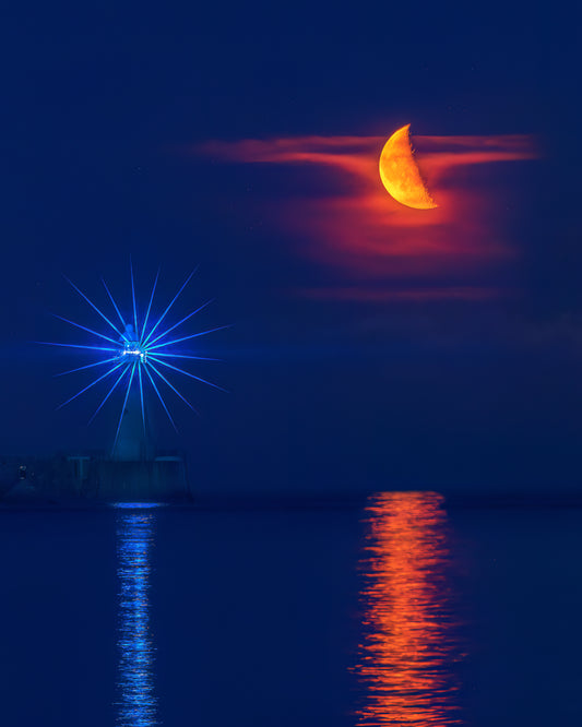 The moon with Tynemouth Lighthouse.