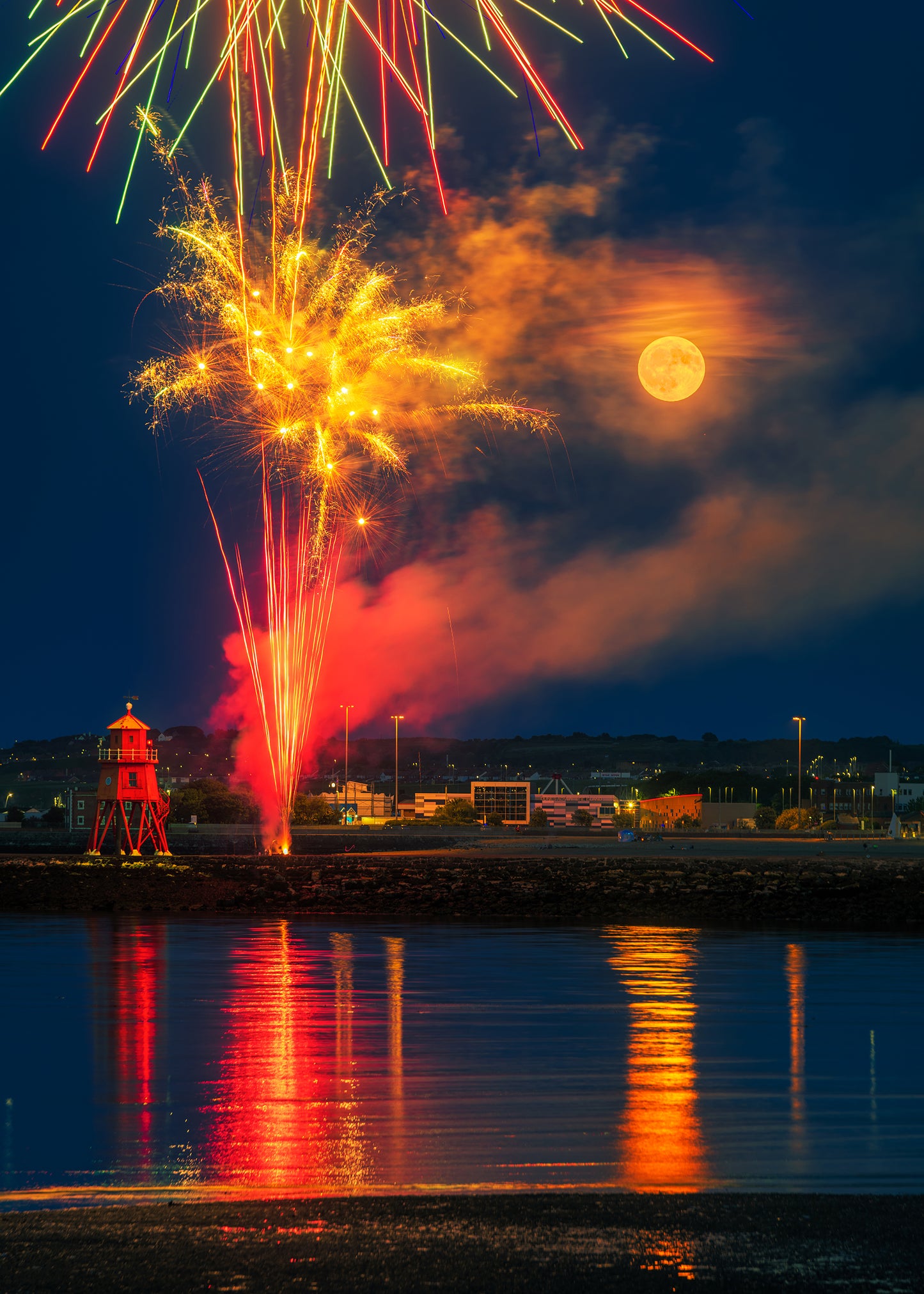 Full moon and fireworks by the Groyne Lighthouse.