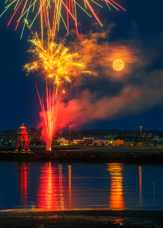 Full moon and fireworks by the Groyne Lighthouse.